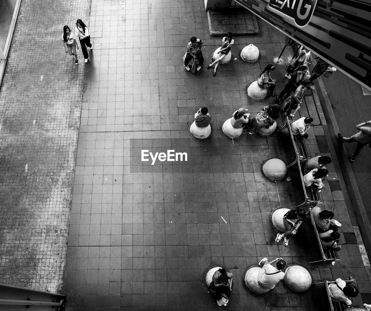 HIGH ANGLE VIEW OF PEOPLE SITTING ON TILED FLOOR