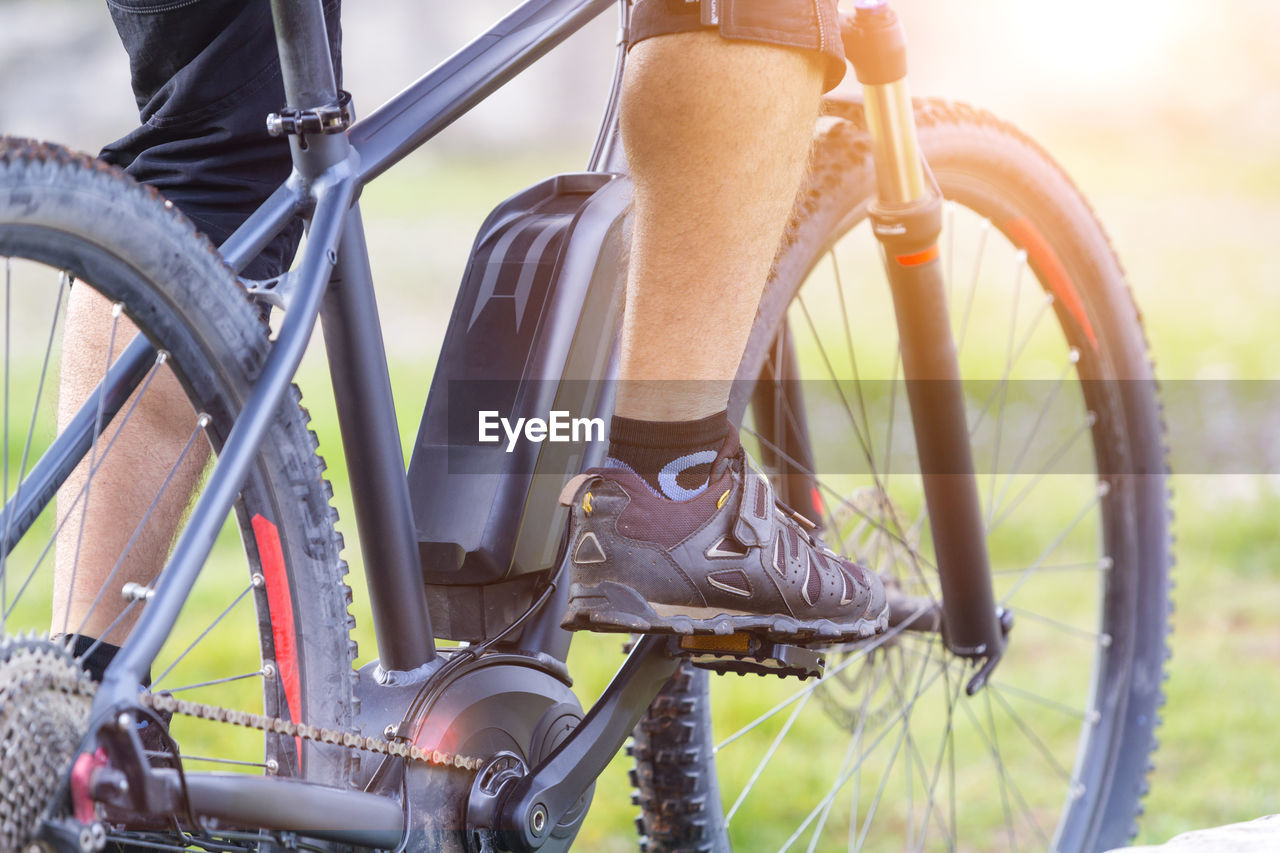 Low section of man riding bicycle at park