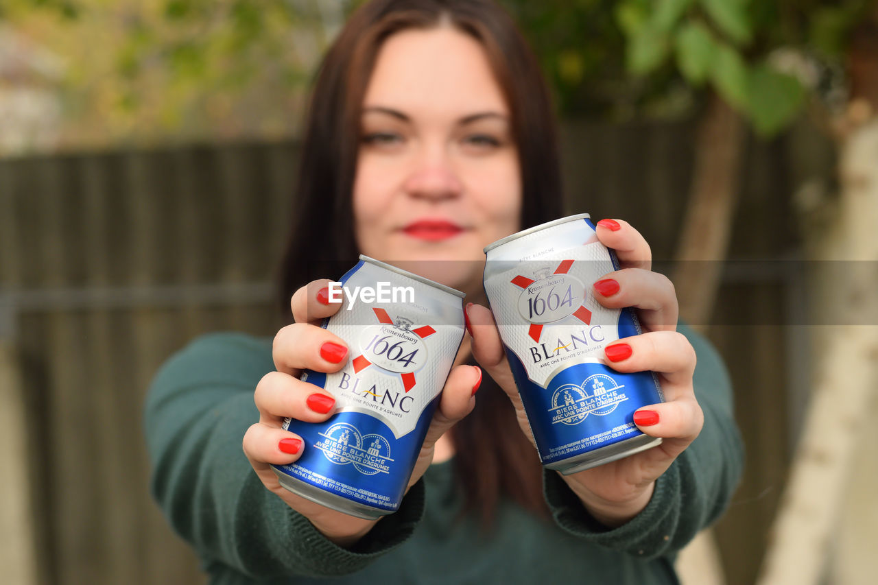 PORTRAIT OF WOMAN HOLDING DRINK