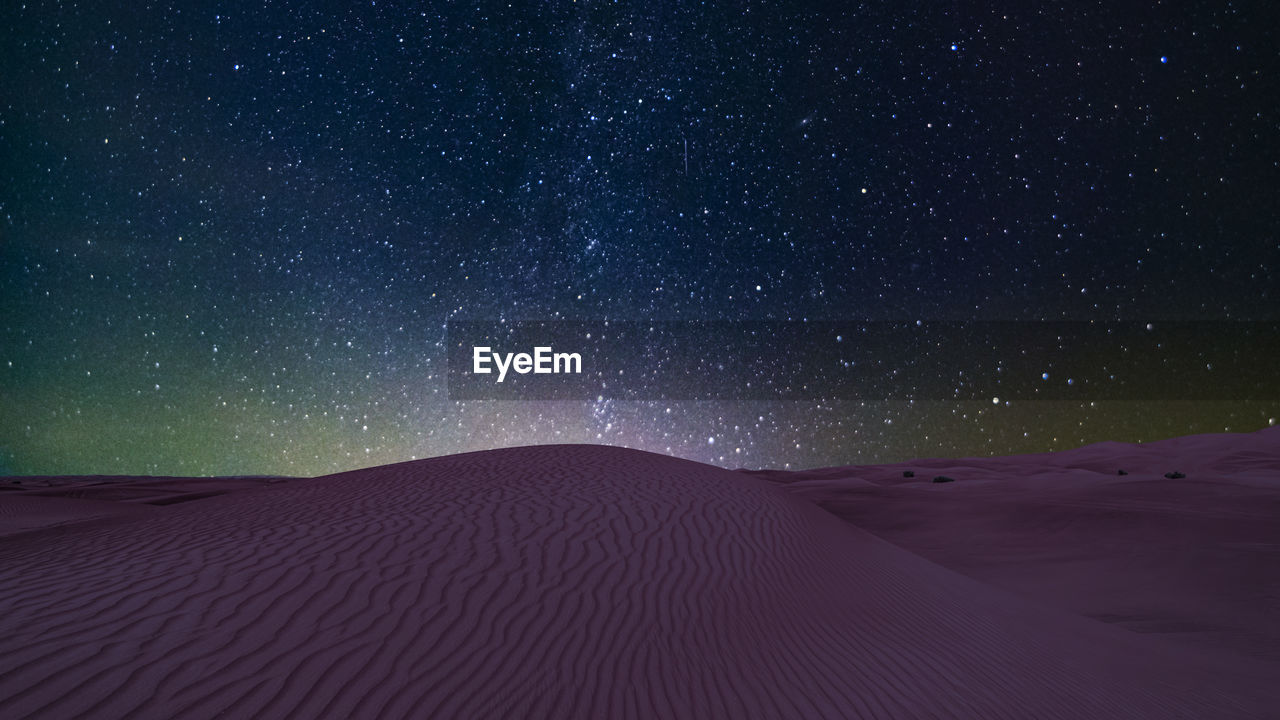 SCENIC VIEW OF DESERT AGAINST STAR FIELD