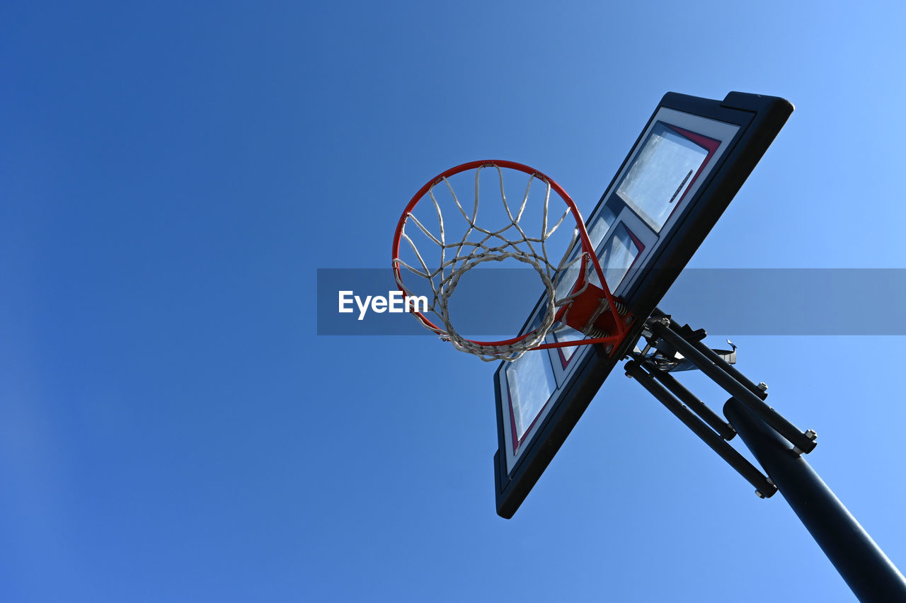 Low angle view of basketball hoop against clear blue sky