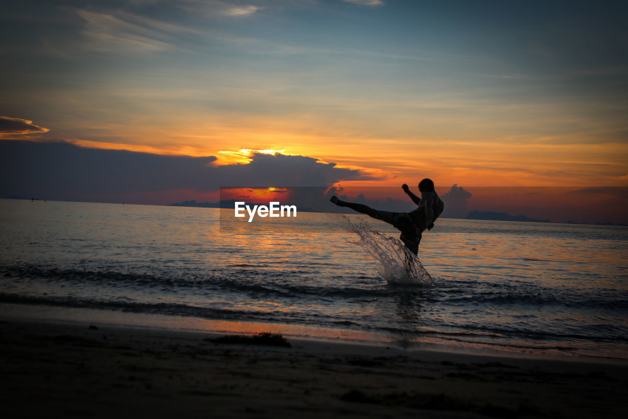 SILHOUETTE PERSON ON BEACH DURING SUNSET