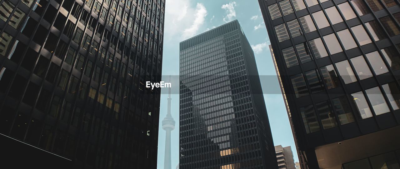 LOW ANGLE VIEW OF MODERN GLASS BUILDINGS IN CITY AGAINST SKY