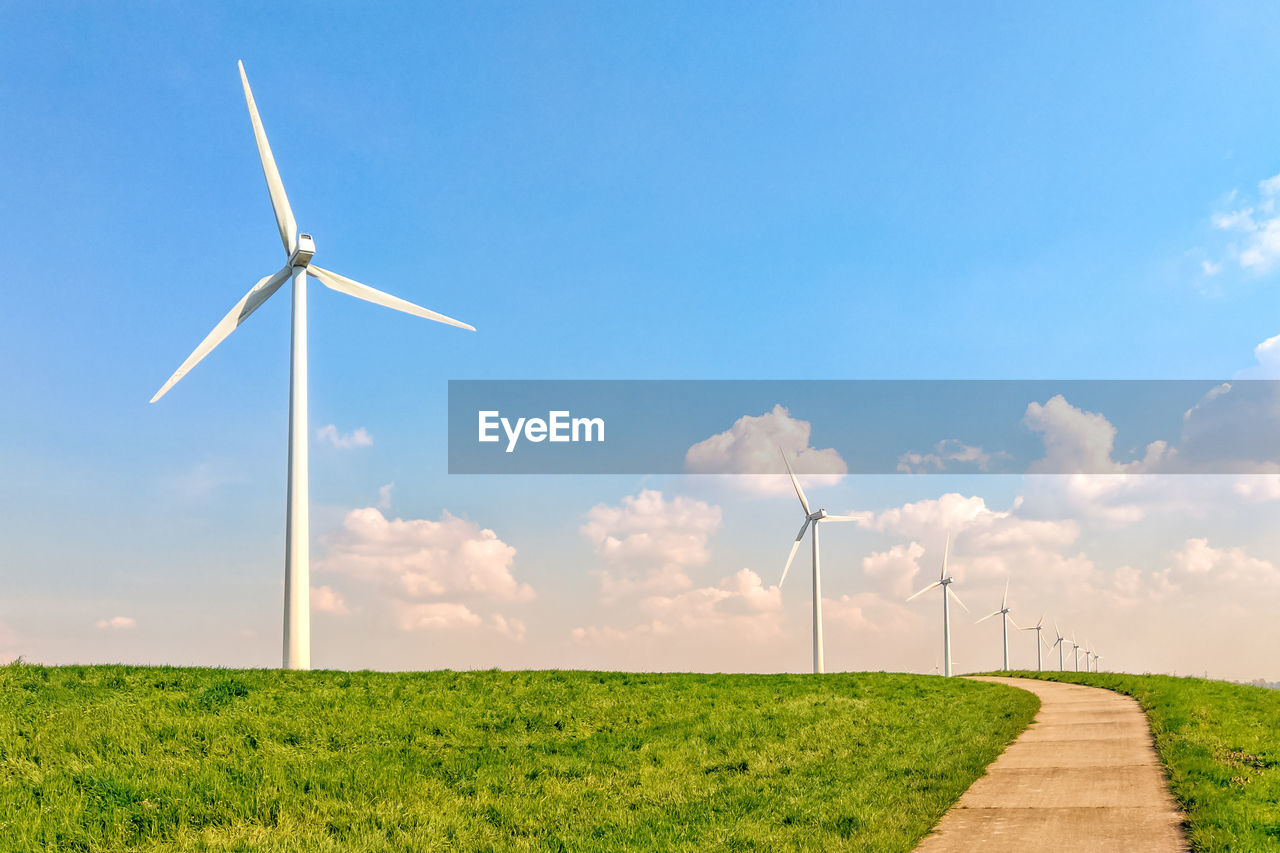 WINDMILL ON FIELD AGAINST BLUE SKY