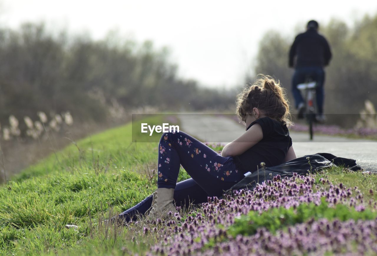 Side view of woman sitting on field