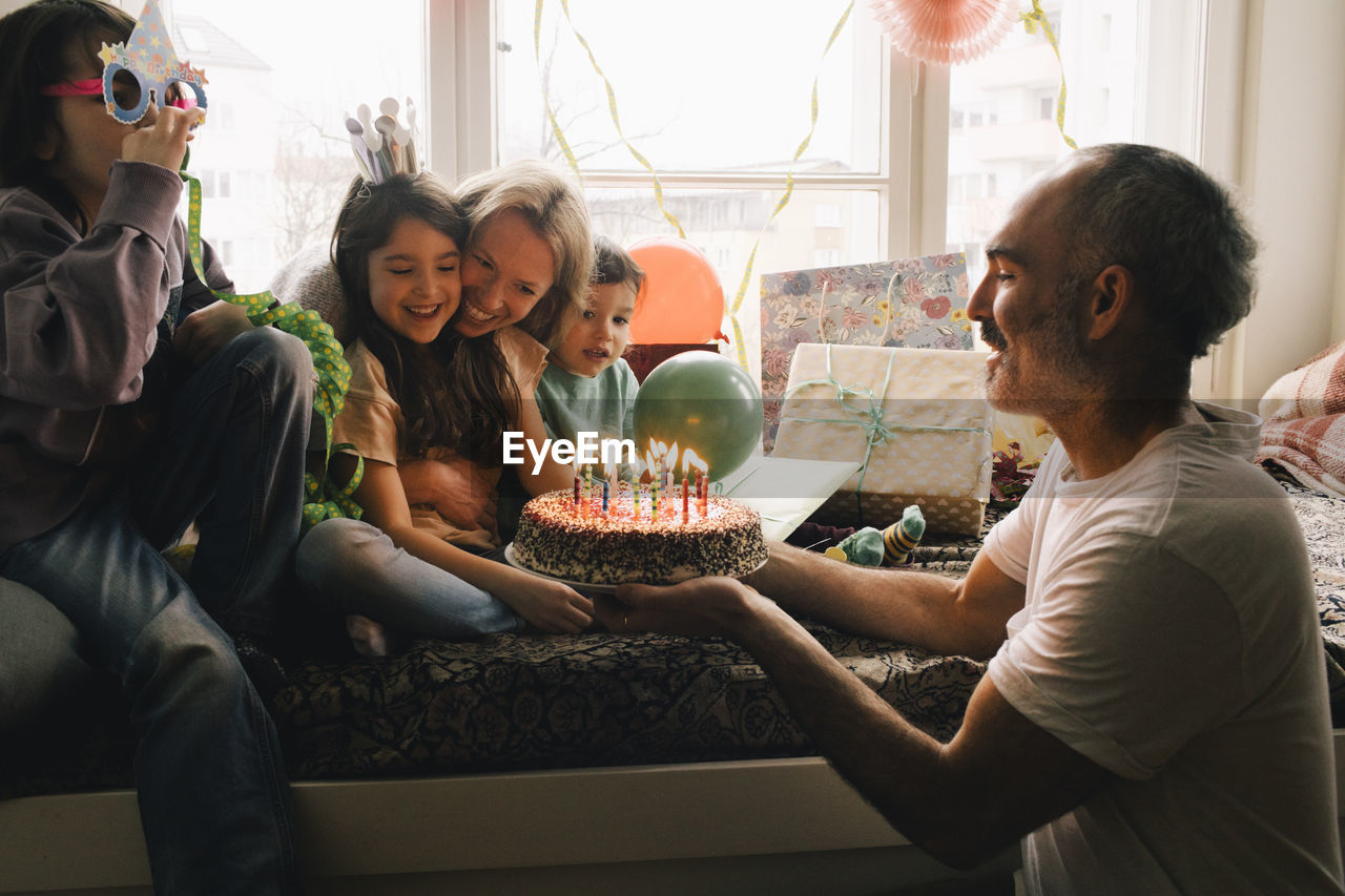 Happy family celebrating birthday with cake at home