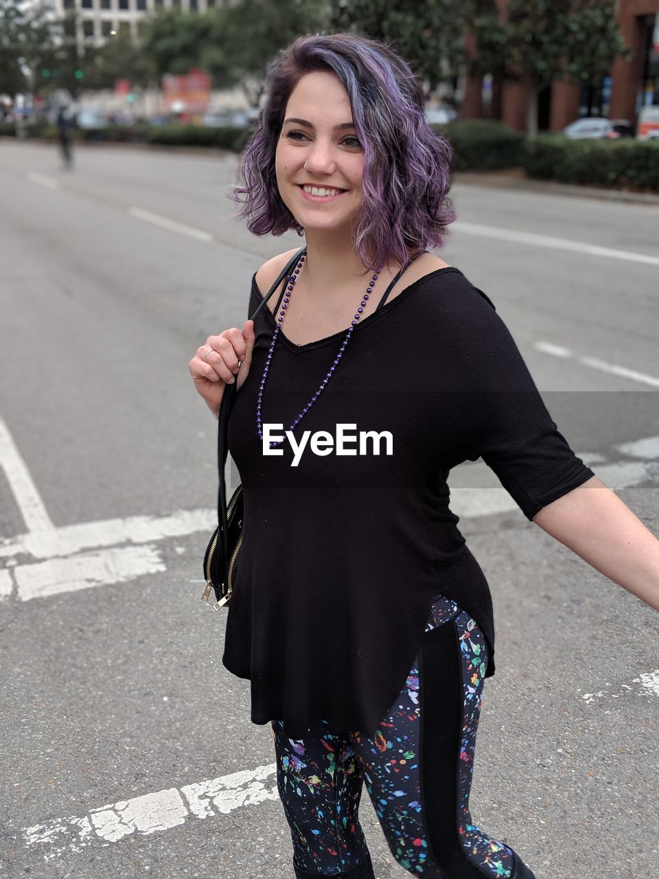 Smiling young woman walking on road