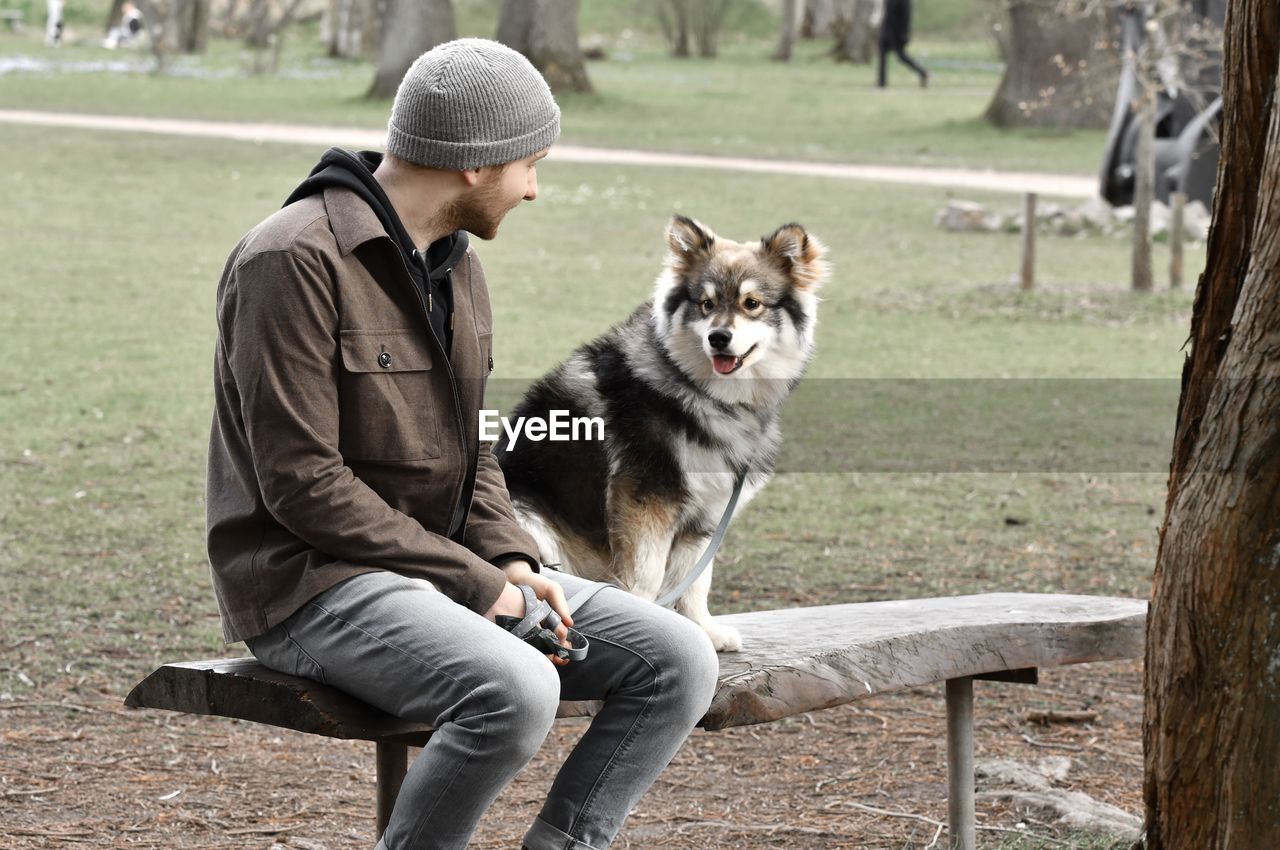 Man with dog sitting on bench