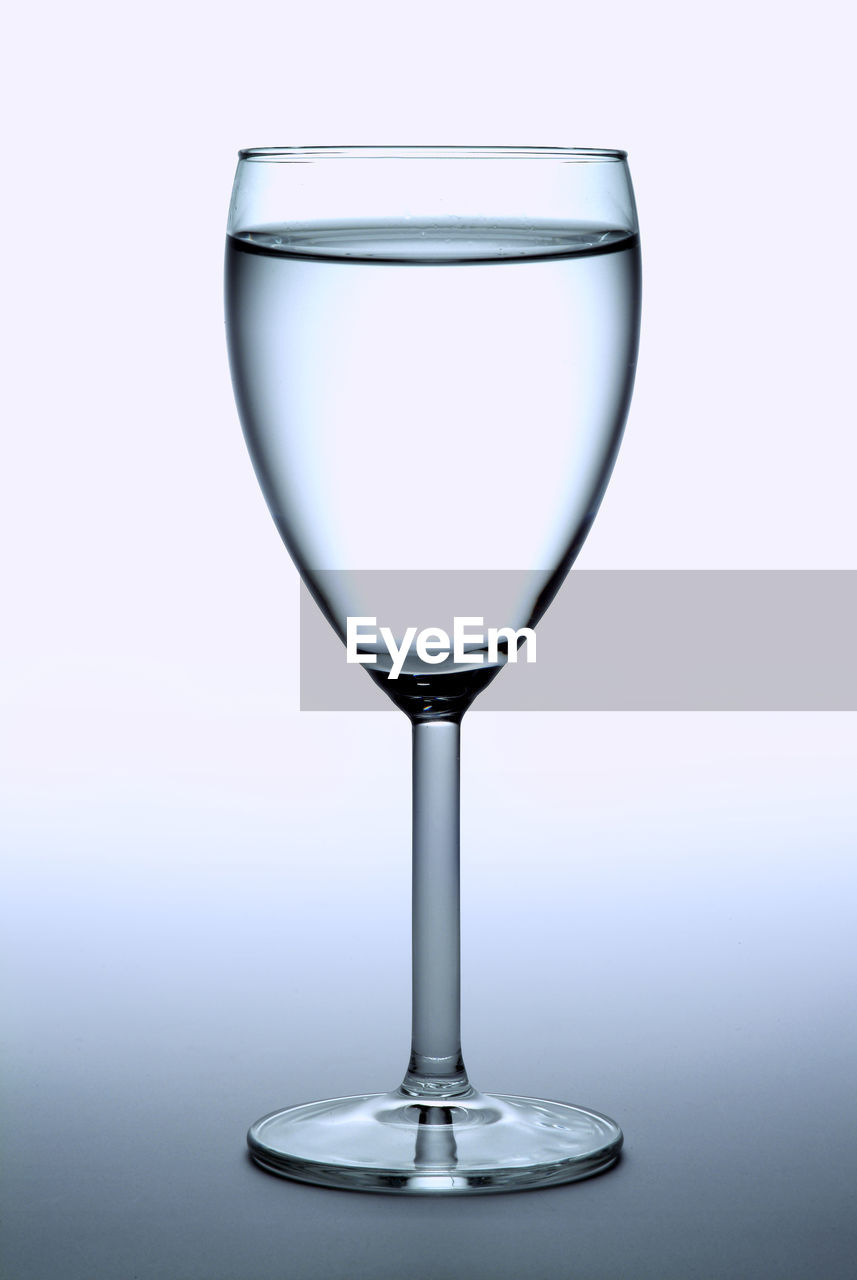 Close-up of water in wineglass against white background