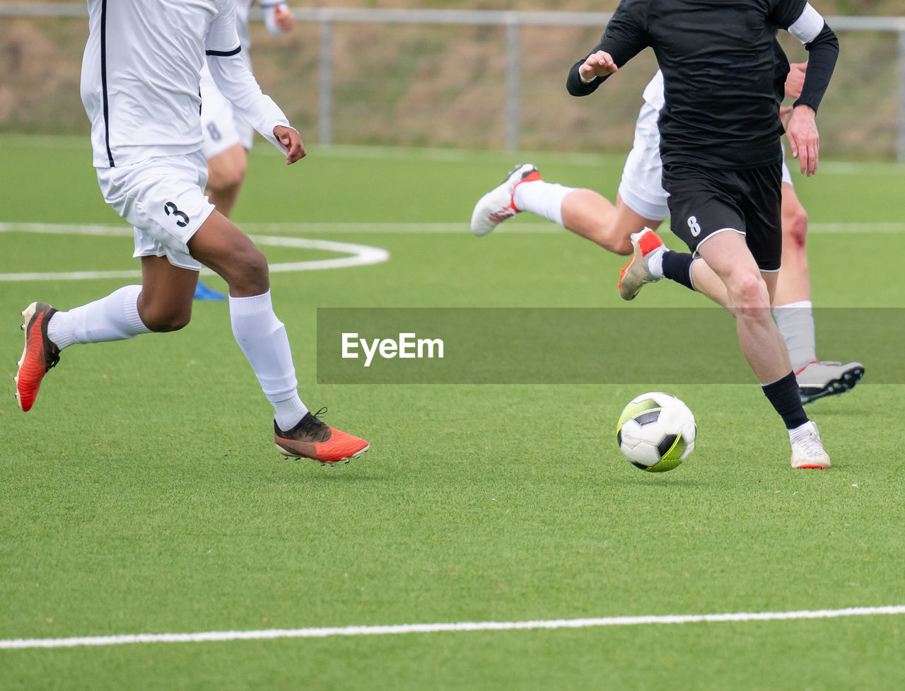 low section of man playing soccer at park