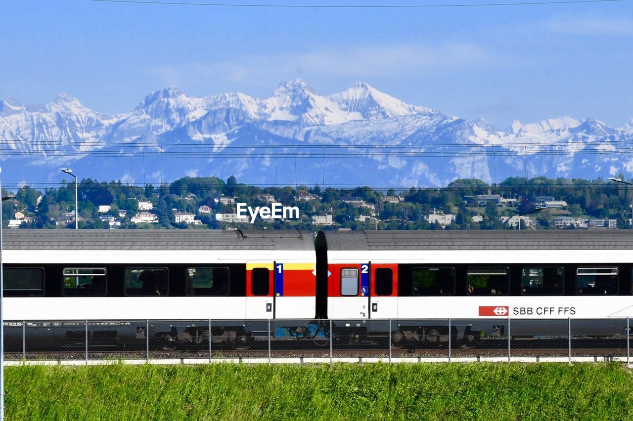 TRAIN AGAINST MOUNTAIN RANGE AND SKY