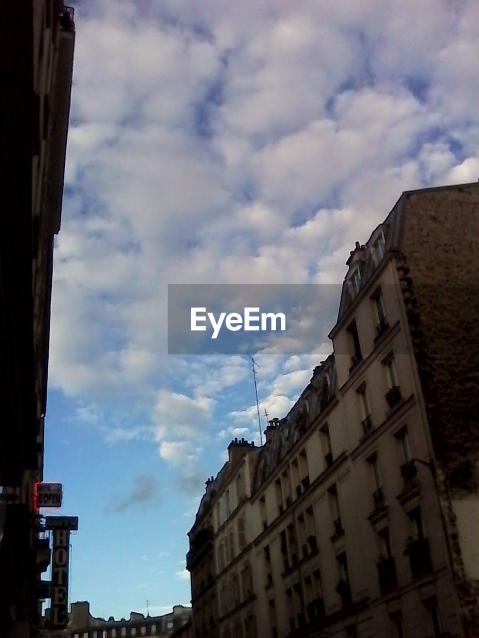 LOW ANGLE VIEW OF BUILDINGS AGAINST CLOUDY SKY