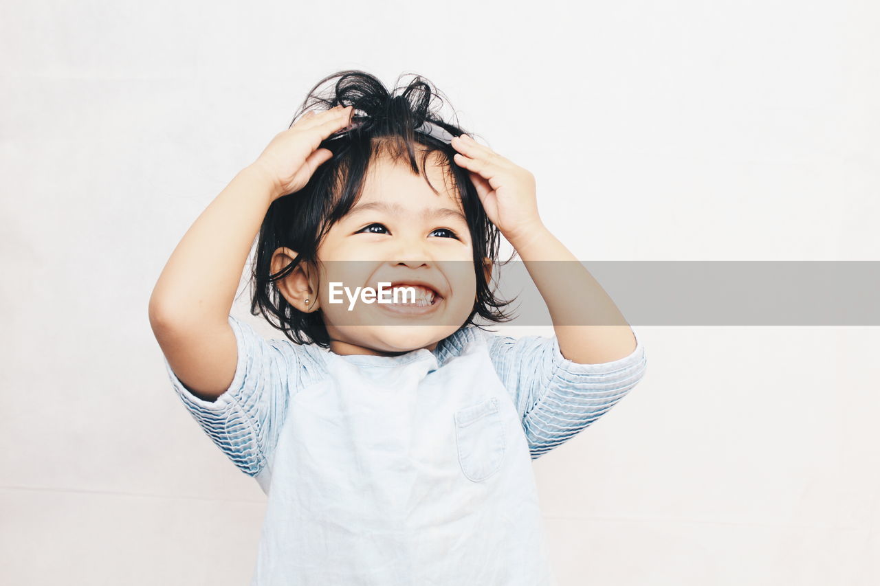 Cheerful girl wearing headband against white background