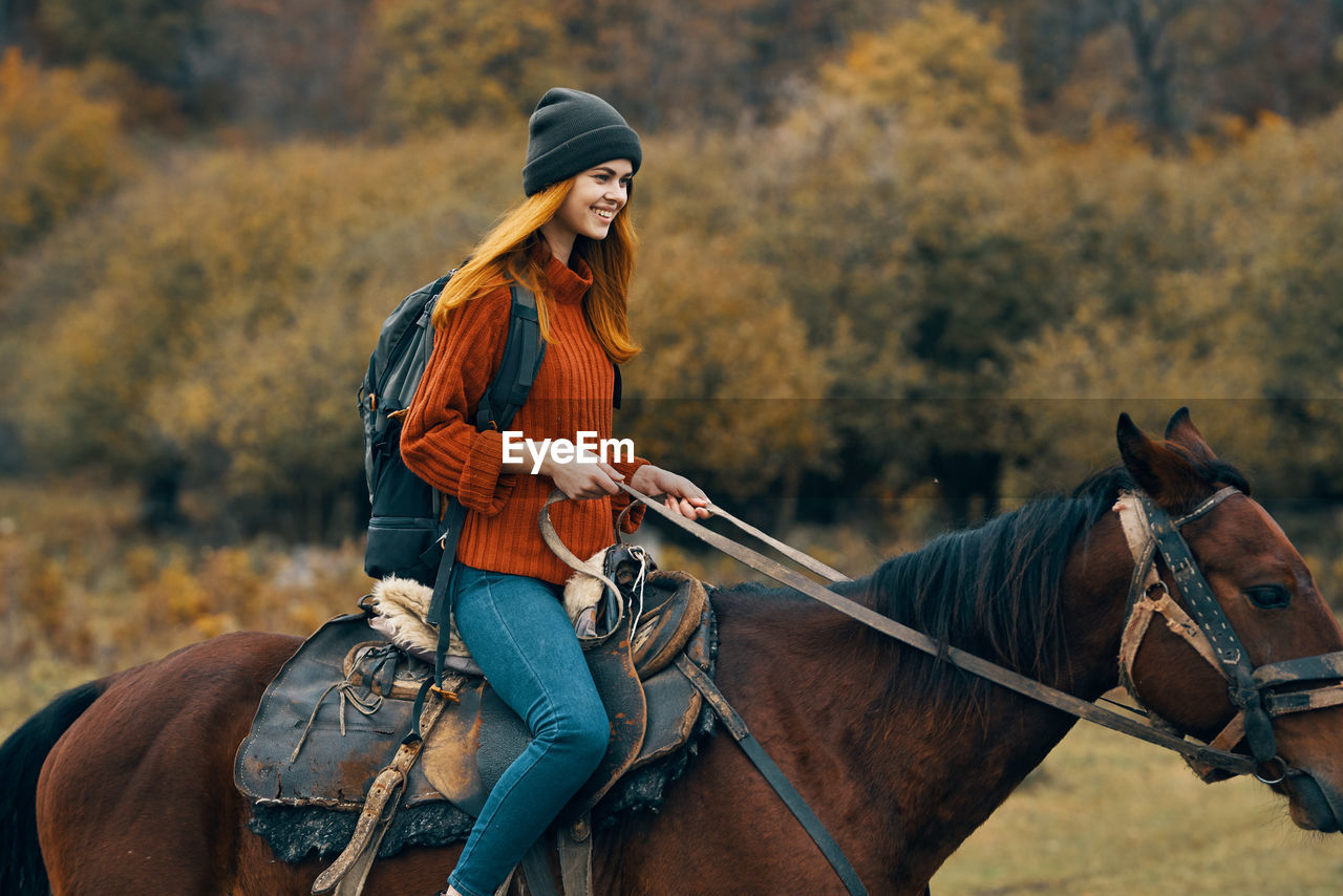 FULL LENGTH OF A YOUNG WOMAN RIDING