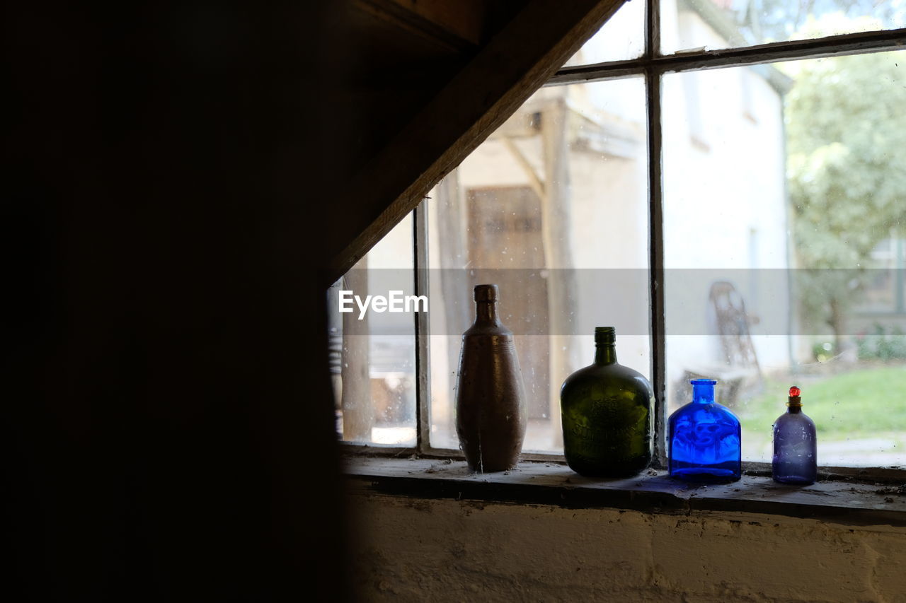 CLOSE-UP OF BOTTLE IN WINDOW SILL