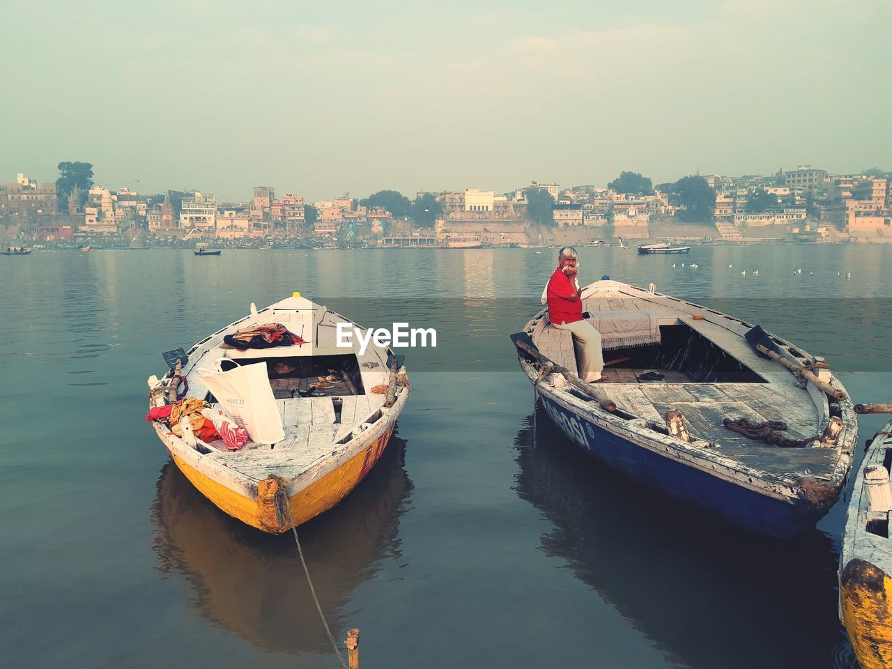 BOATS MOORED IN SEA AGAINST CITY