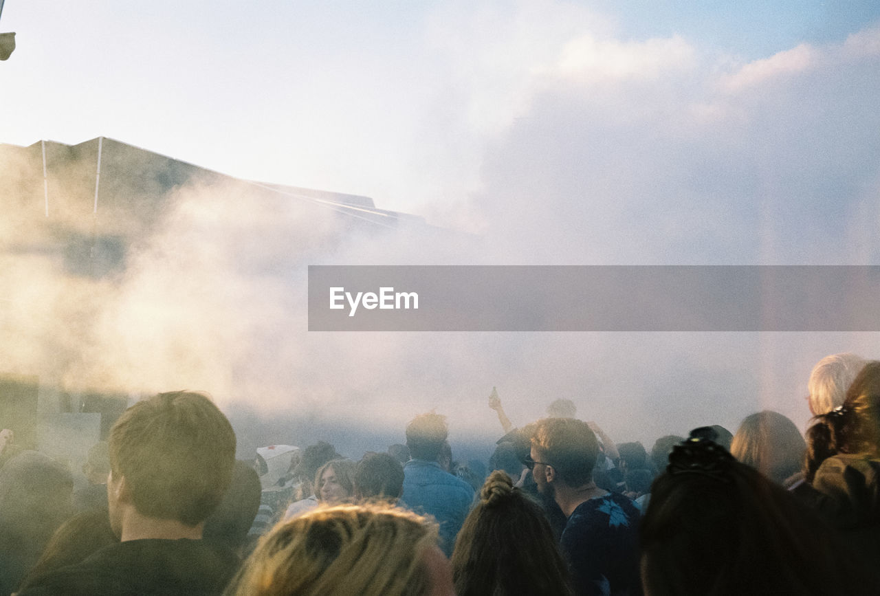 REAR VIEW OF PEOPLE LOOKING AT MUSIC CONCERT