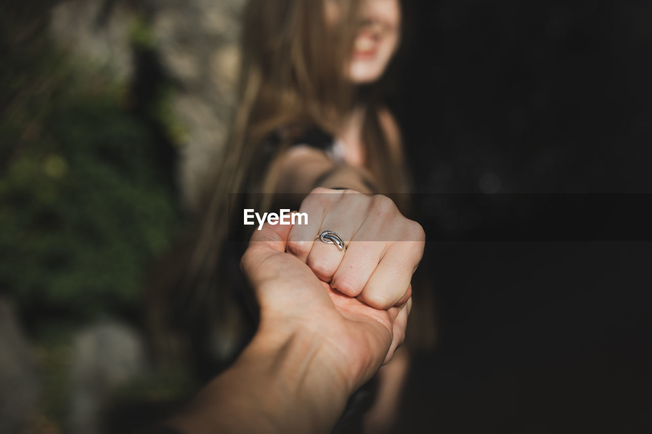 Close-up of woman hand holding hands against blurred background