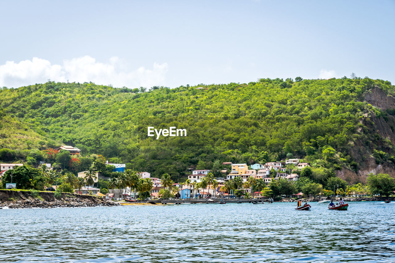 Houses by river against mountain