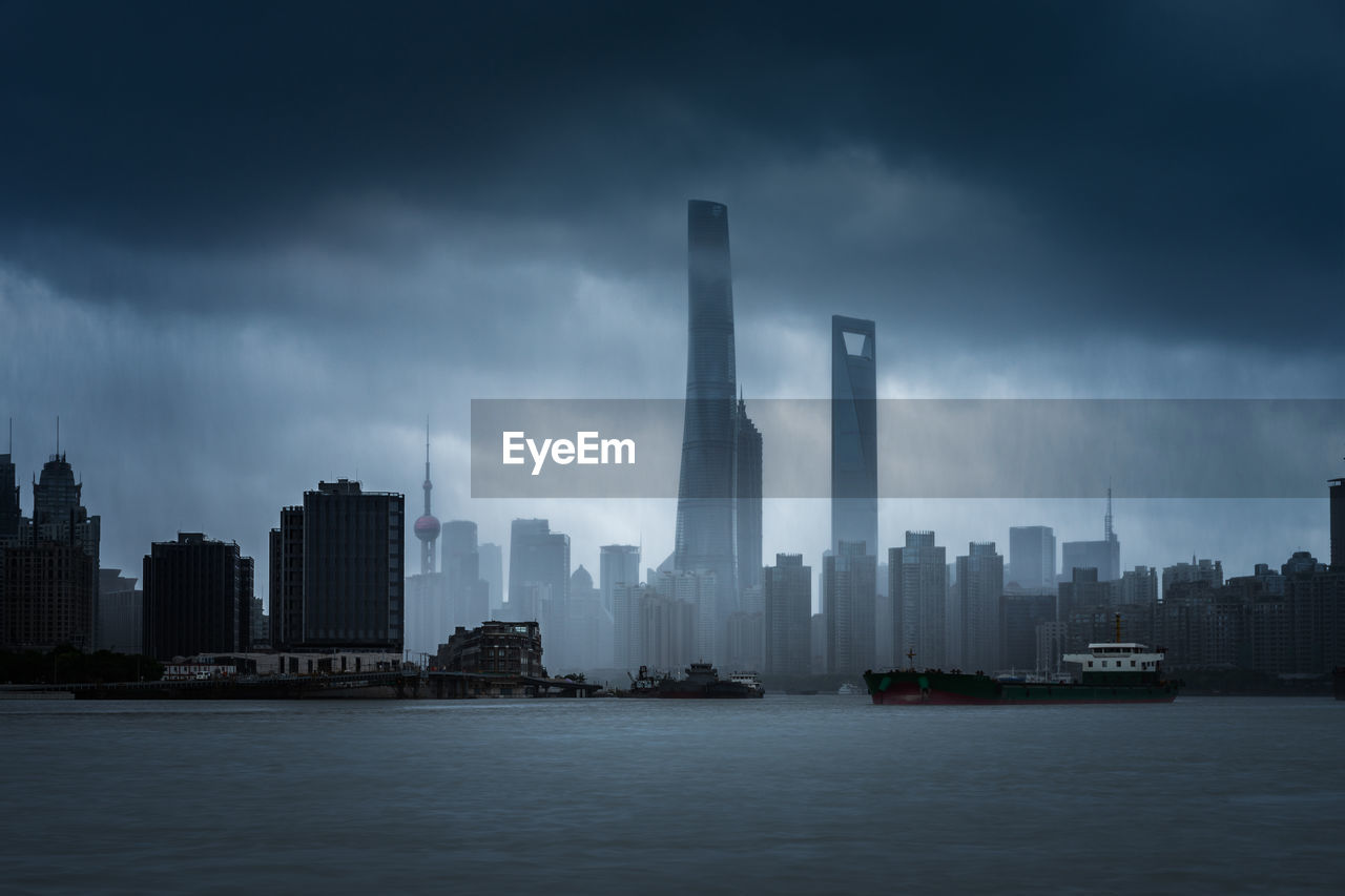 Modern buildings in city against cloudy sky