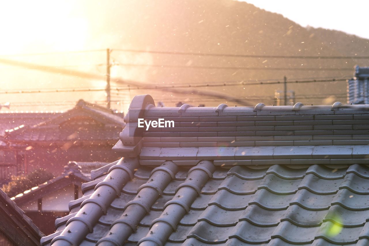 Close-up of snow on built structure against sky