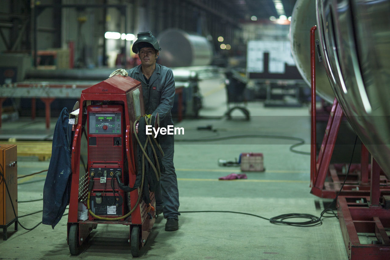 Worker with machine in factory