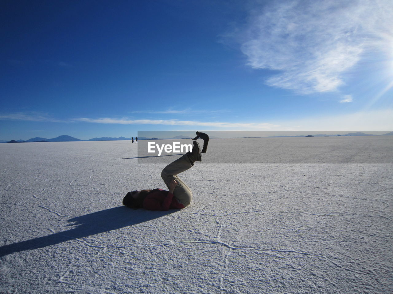 Optical illusion of woman lifting man at salar de uyuni