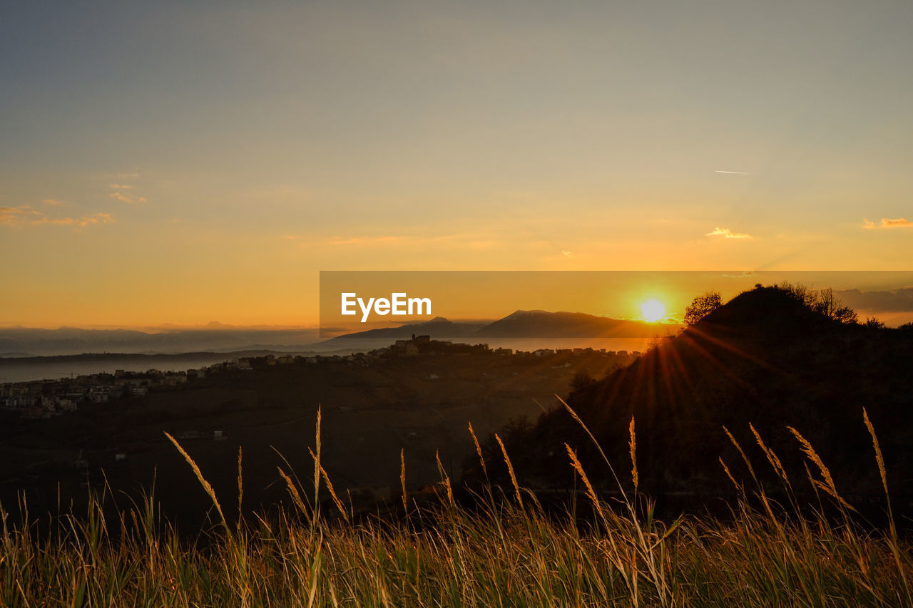 Scenic view of field against sky during sunset