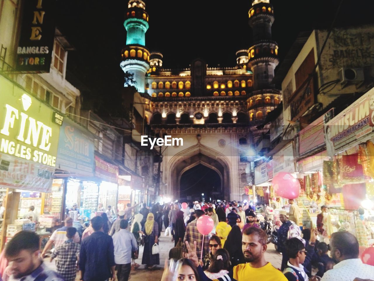 architecture, crowd, large group of people, city, group of people, building exterior, built structure, illuminated, night, travel destinations, city life, street, travel, tourism, bazaar, market, adult, women, men, building, city street, lifestyles, celebration, clothing, outdoors