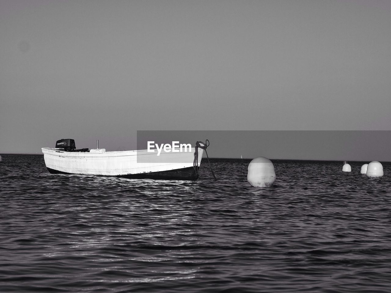 Boat moored in sea against clear sky