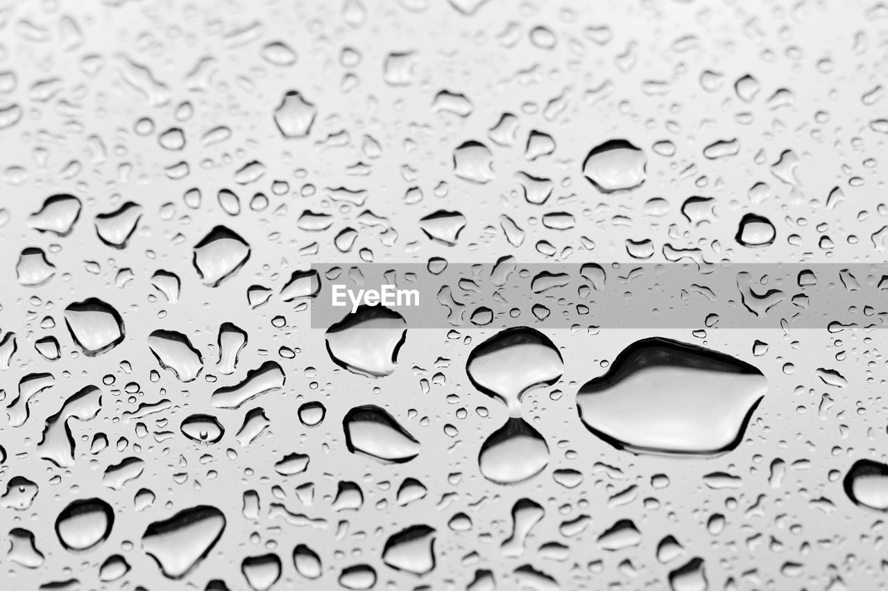 FULL FRAME SHOT OF WATER DROPS ON GLASS