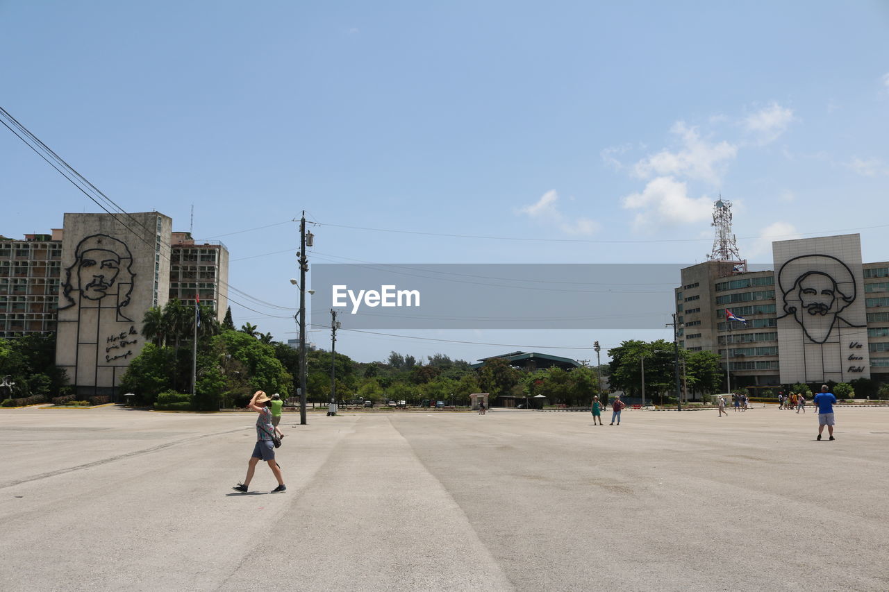 WOMAN WALKING ON ROAD IN CITY