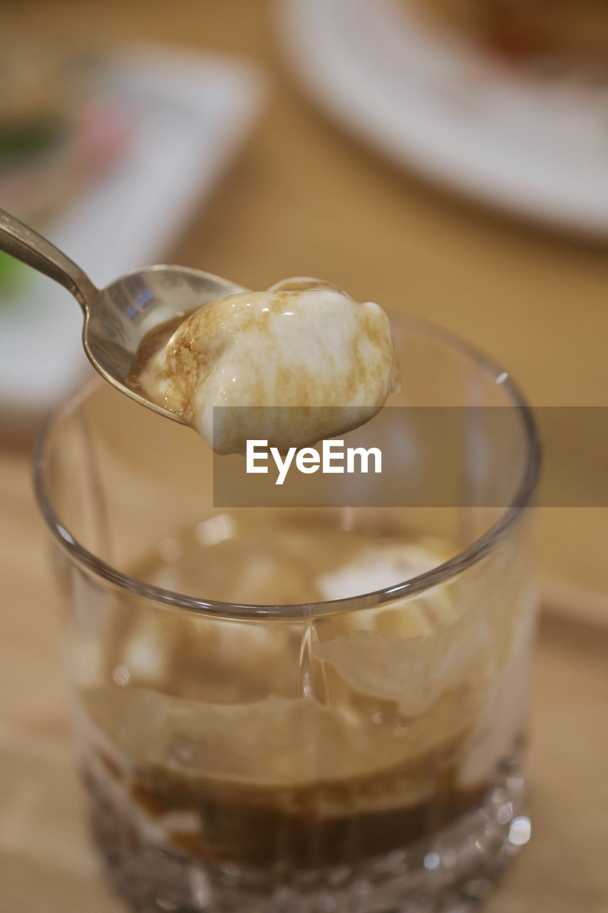 CLOSE-UP OF ICE CREAM ON GLASS