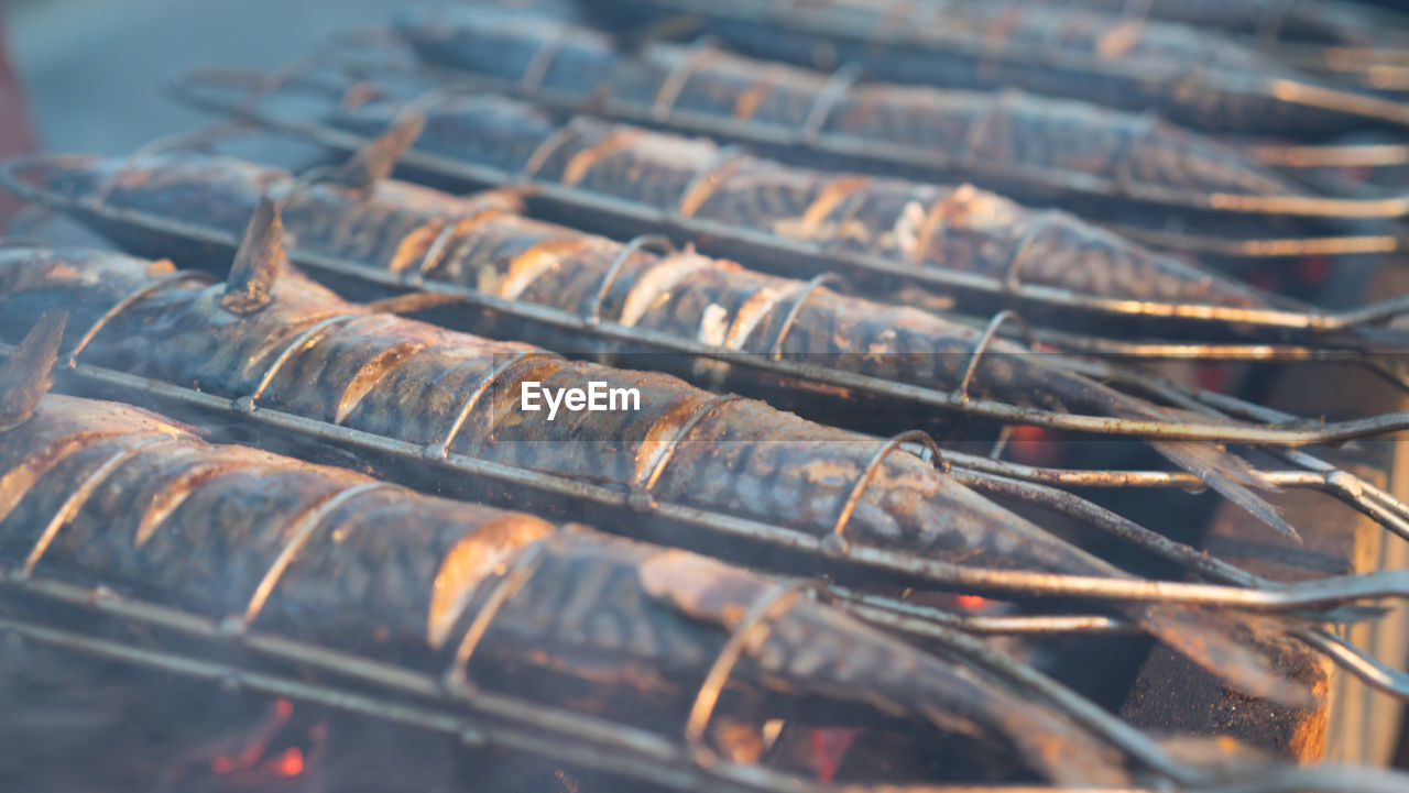 Close-up of mackerels cooking on barbecue grill