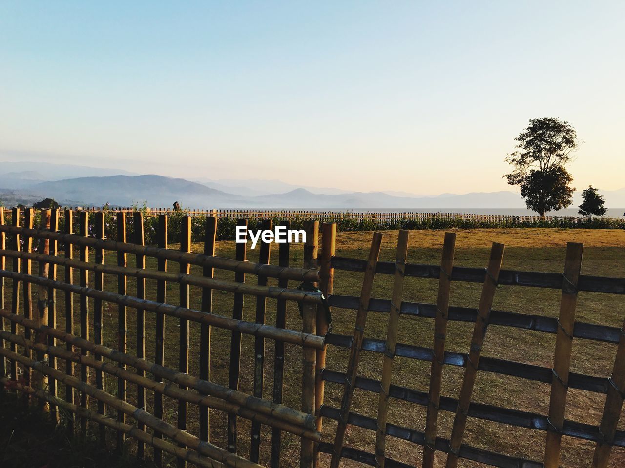 Wooden posts on field against clear sky