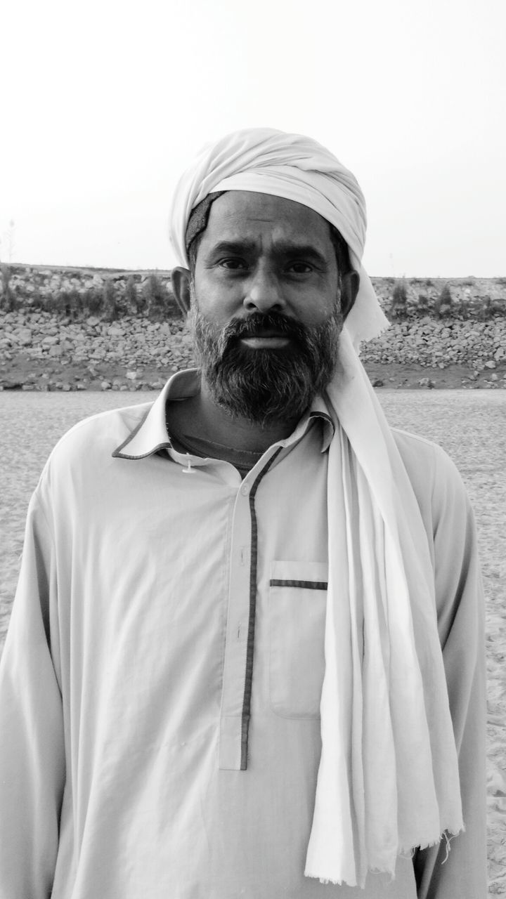 PORTRAIT OF MID ADULT MAN STANDING ON BEACH