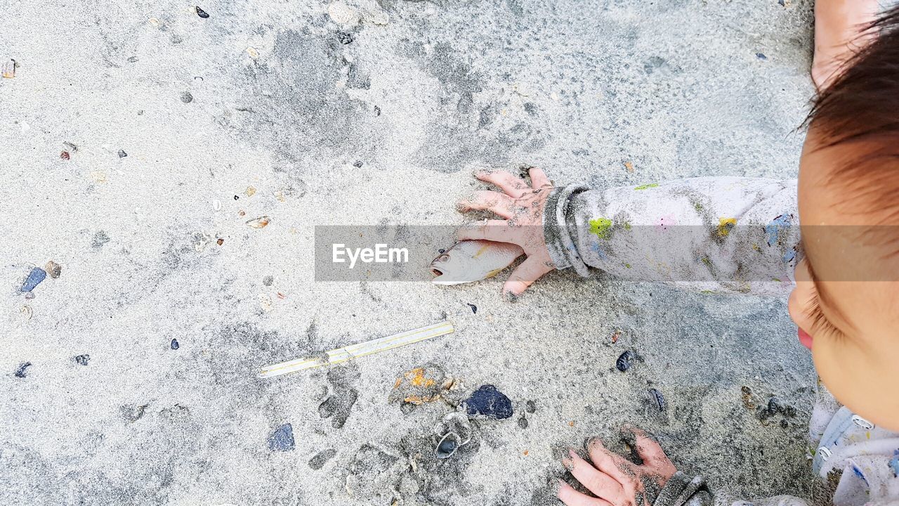 LOW SECTION OF HUMAN FEET ON SAND