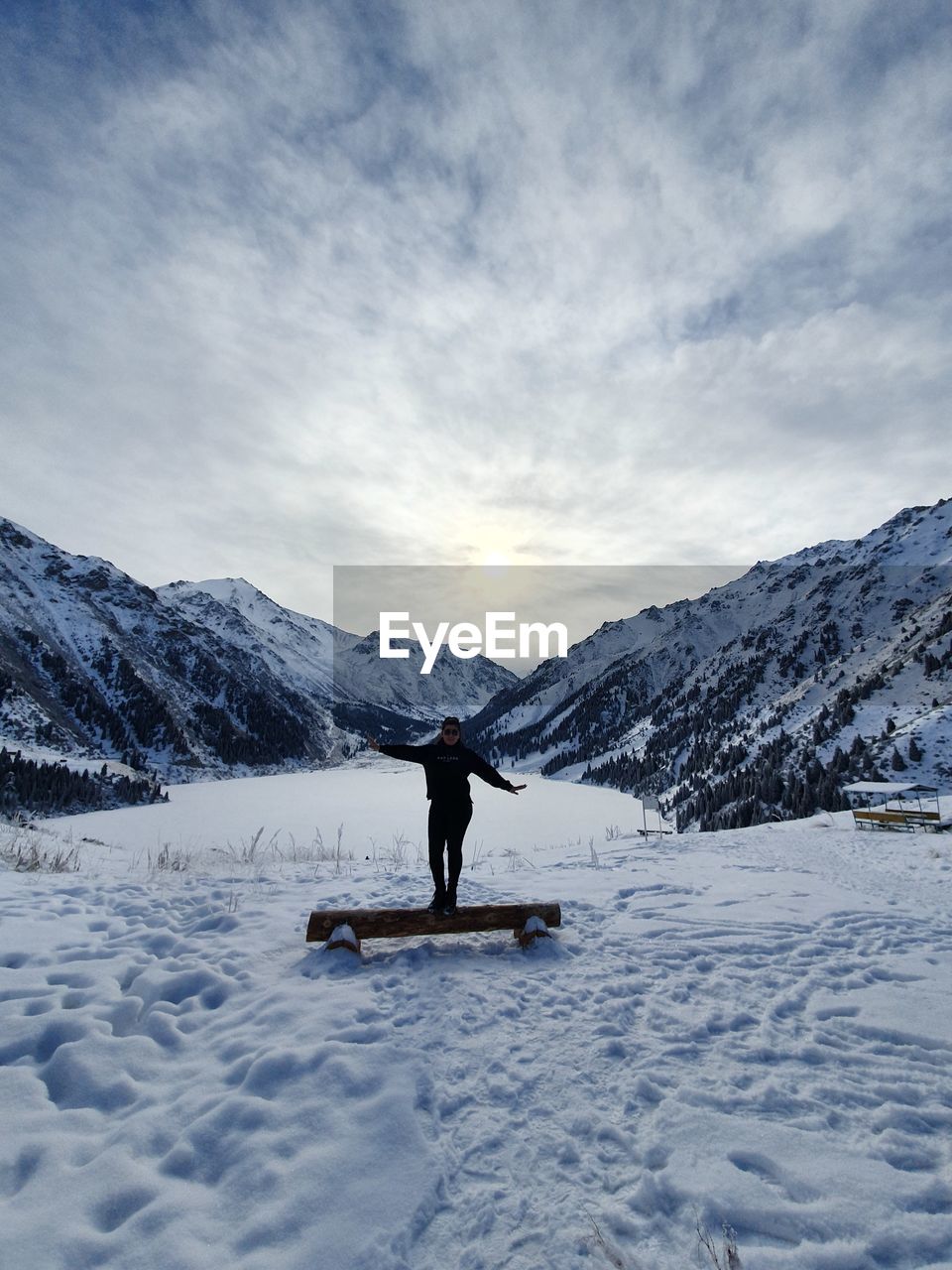 Woman on snowcapped mountain against sky