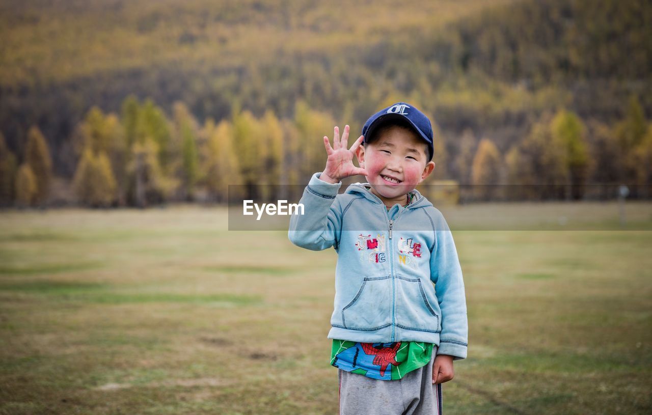 PORTRAIT OF SMILING BOY IN GRASS