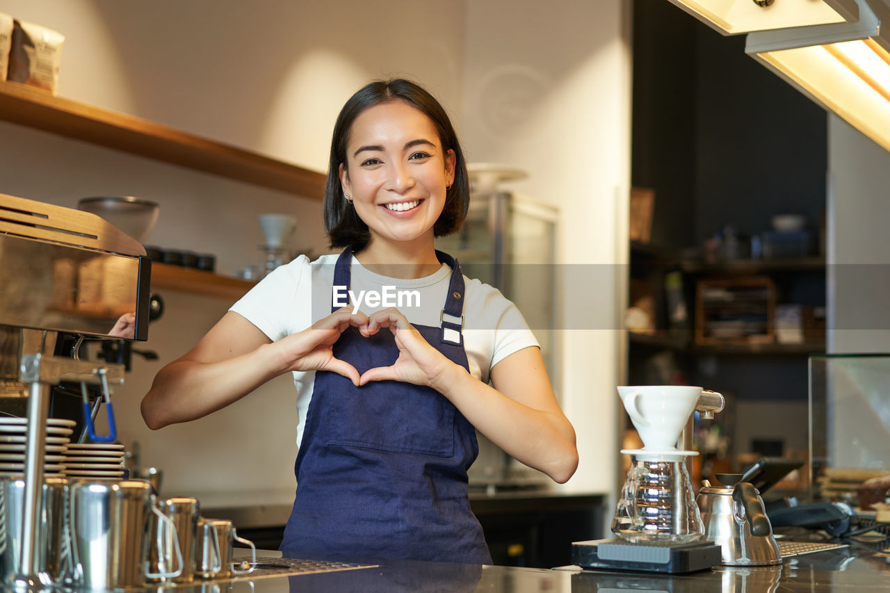 portrait of young woman using mobile phone while sitting at home