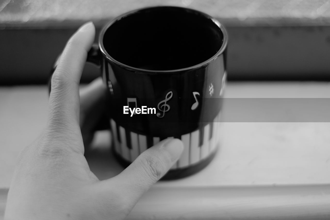 MIDSECTION OF PERSON HOLDING COFFEE CUP
