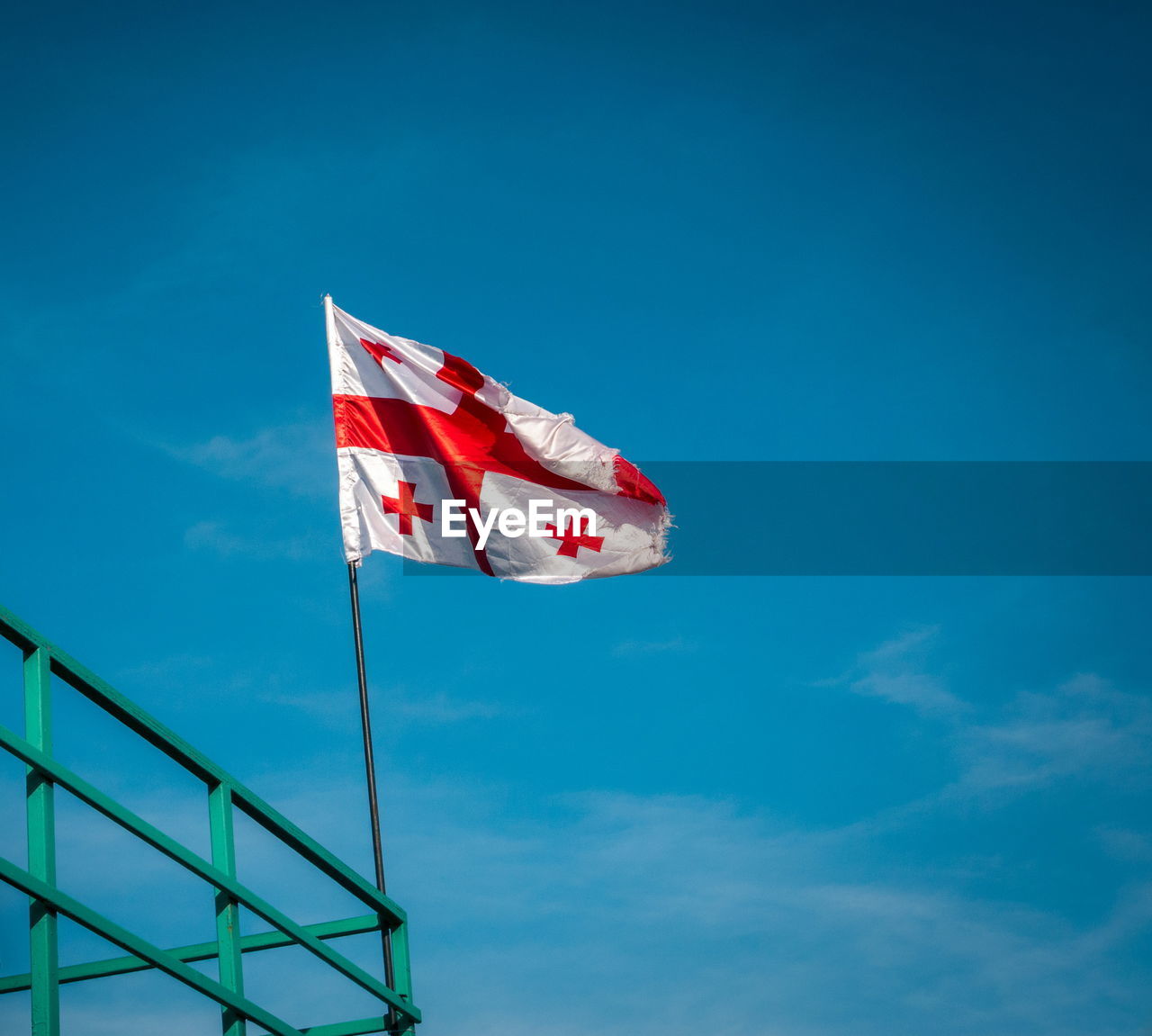 Low angle view of flag against blue sky