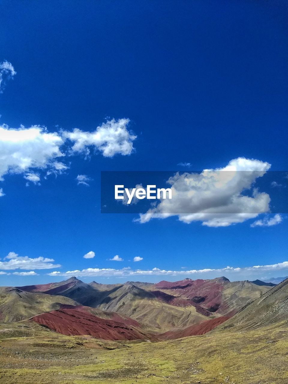 SCENIC VIEW OF LAND AND MOUNTAINS AGAINST BLUE SKY