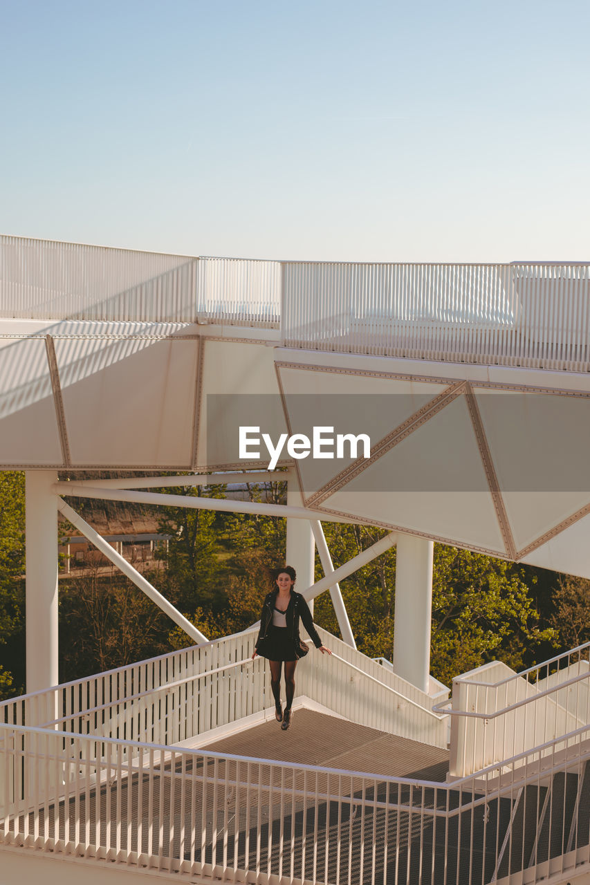 Young woman standing by railing