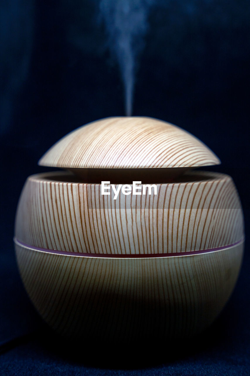 A round wooden texture humidifier spreading steam into the living room. ultrasonic humidifier