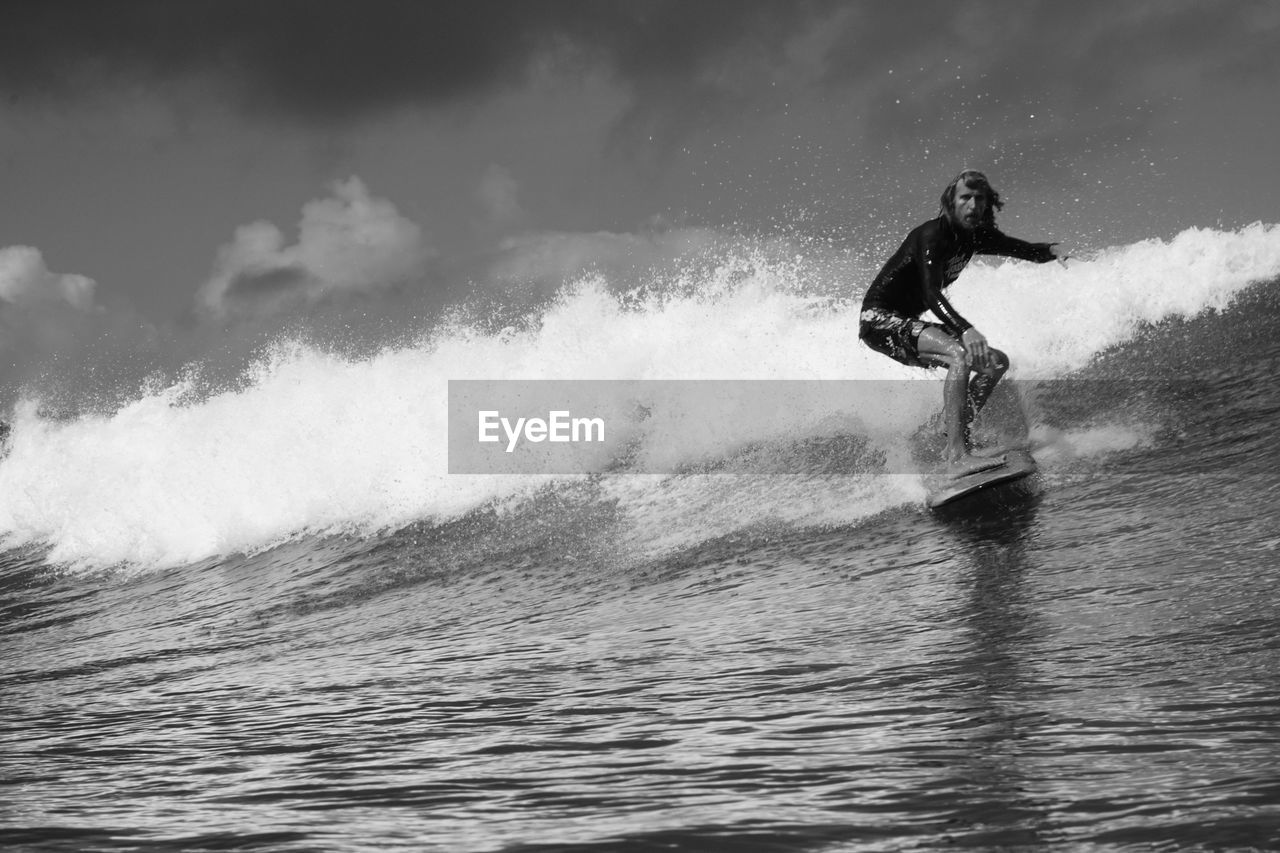 Man riding surfboard in sea