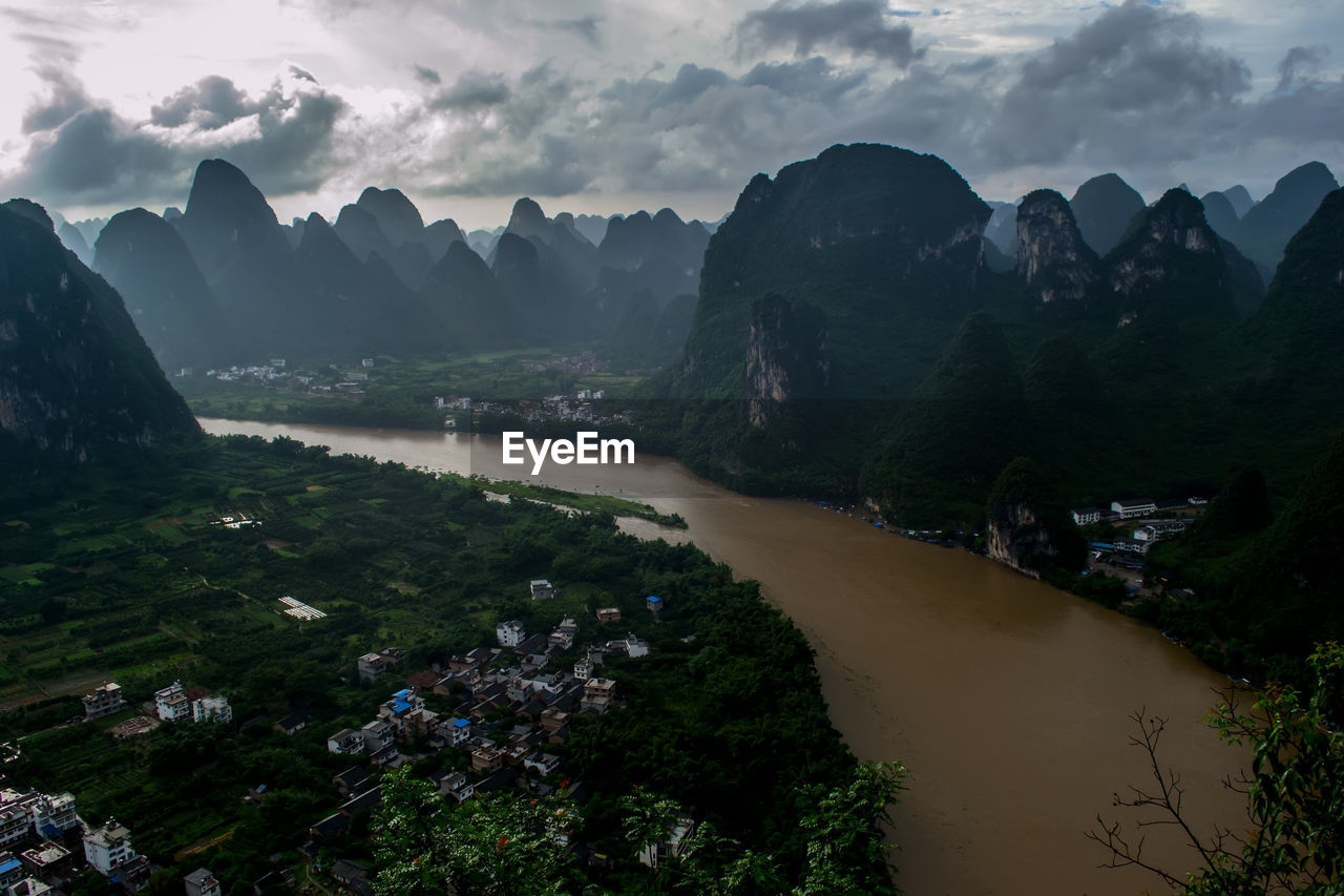 Scenic view of river and mountains against sky