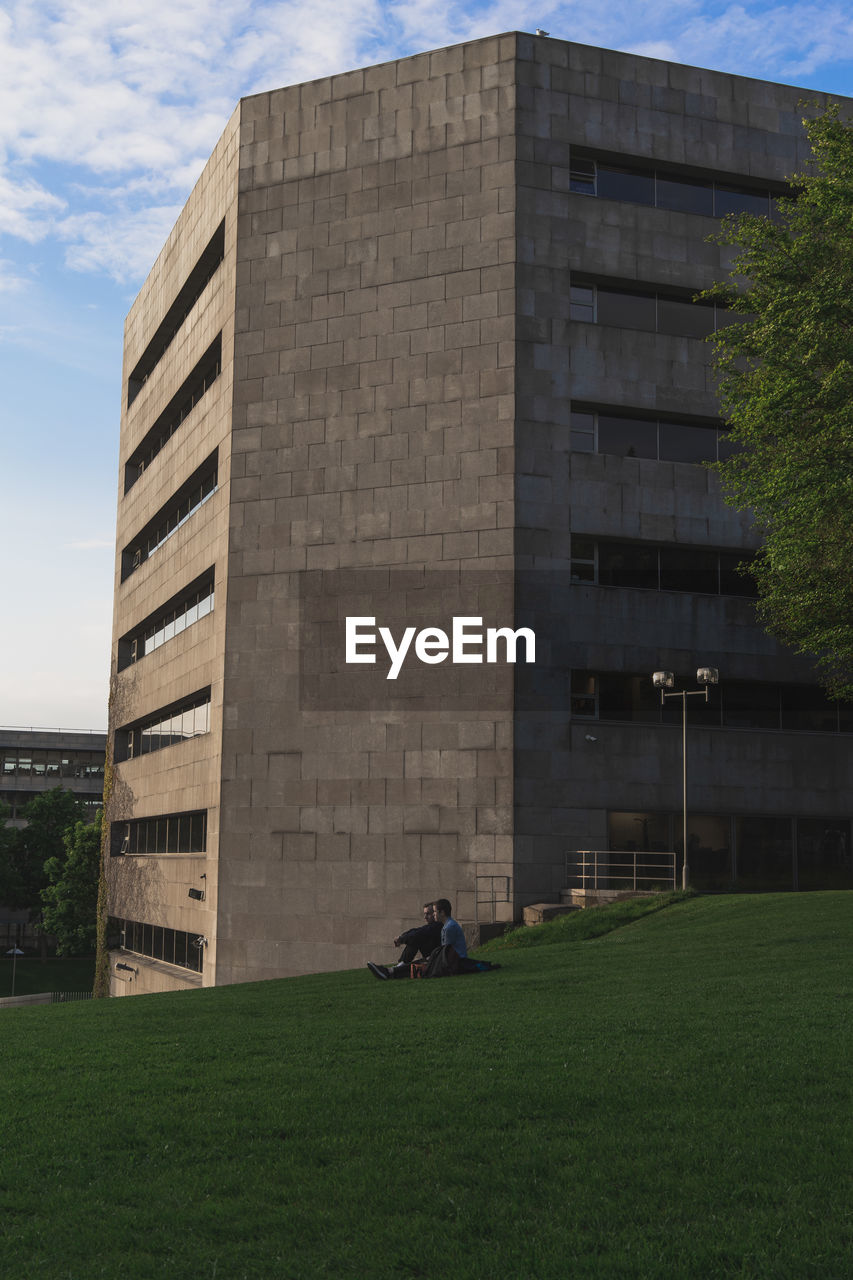 BUILDING ON FIELD AGAINST SKY