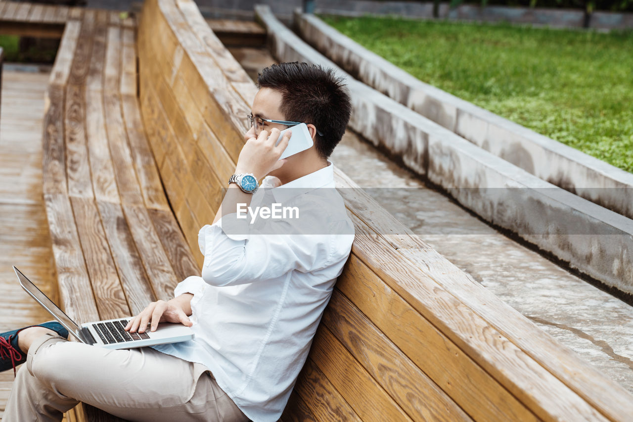 Side view of senior man sitting on wood