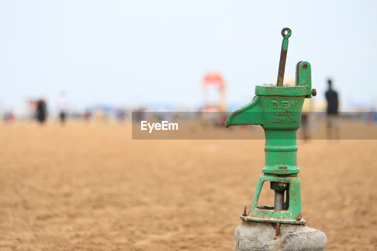 Metal equipment at beach against sky